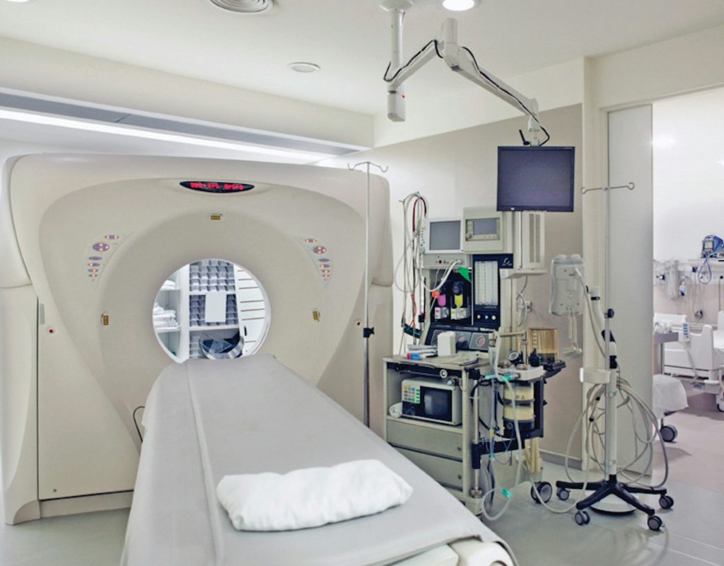 Sala de medicina nuclear con equipos de imagen y preparación de dosis